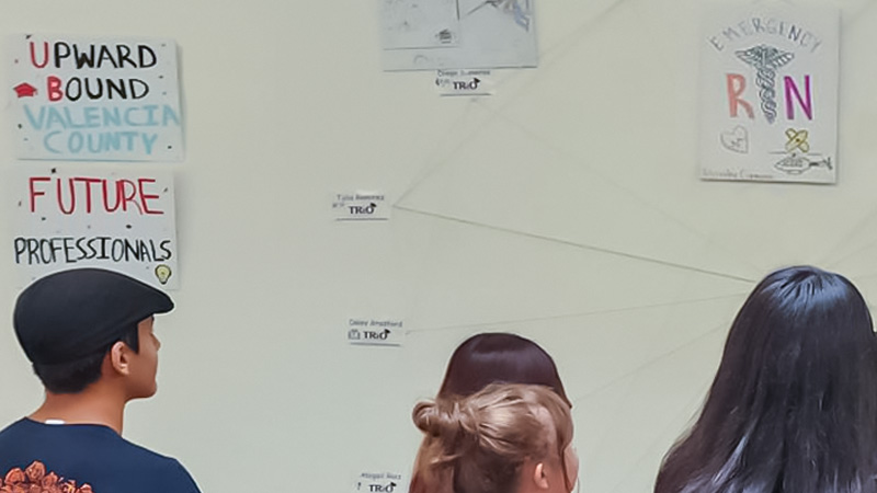 Upward Bound students decorate a wall with their future professions